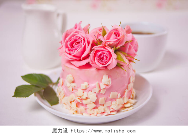白色桌子上的鲜花和蛋糕有粉色釉料的小蛋糕，漂亮的玫瑰，一杯咖啡，白桌子上的礼品盒